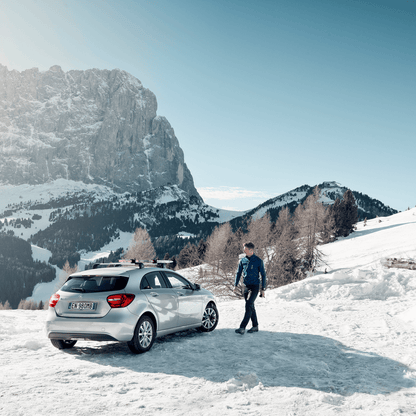 A man is walking towards his car in a snowy landscape